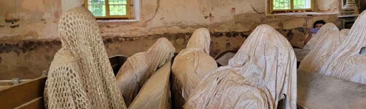 church pews full of shrouded human figures.